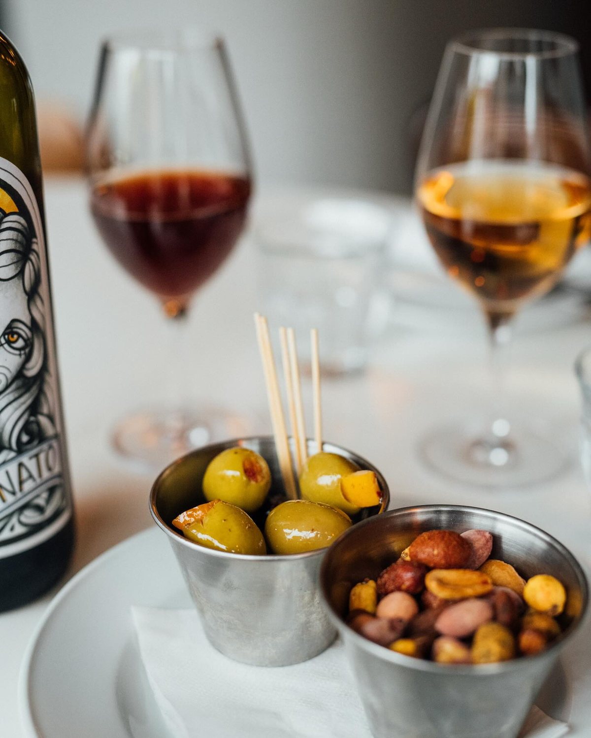 Deux verres de vin, olives et noix